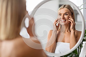 Anti-Aging Cosmetics. Beautiful Middle Aged Woman Applying Eye Cream At Home