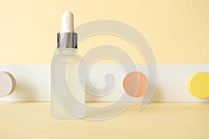 Anti-aging hyaluronic acid facial serum on pastel yellow background with neo-geometric conceptualism decor, front view. Mockup