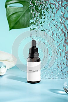 Anti aging squalane. serum with collagen and peptides on blue surface with shadows. Hyaluronic acid oil mockup. serum