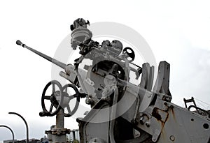 Anti Aircraft Cannon On A Military Ship Over Modern City