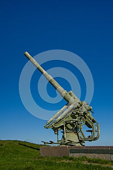 Anti-aircraft gun on a granite pedestal, on the background of sky