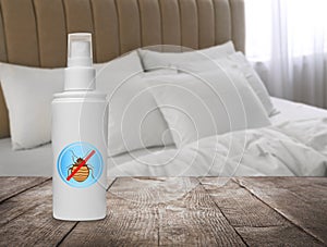 Anti bed bug spray on wooden table in bedroom. Space for text