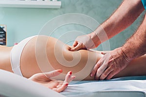 Anti-cellulite massage on the legs of young women.