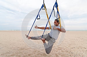 Anti-gravity Yoga, man doing yoga exercises or fly-yoga on the sea background