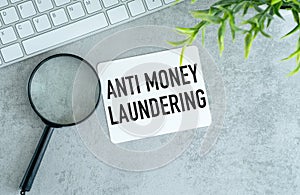 Anti-money laundering AML . text on white paper and white sticker on gray table