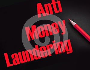 Anti Money Laundering words on black and red pencil besides. AML social govermental and business concept