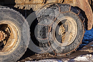 Anti-skid chain on freight truck wheels at winter daylight closeup