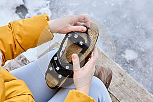 Anti-slip device for winter shoes, spikes on rubber backing, are put on sole to improve traction and prevent slipping in