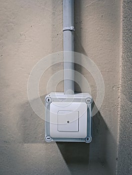 Anti-theft pushbutton with light grey surface on cement wall in