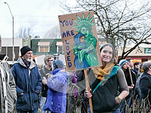 Anti-Trump demonstrator holds emotional Statue of Liberty sign at Oregon rally