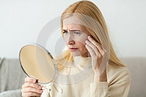 Anti-Wrinkle Skin Care. Sad Woman Looking In Mirror