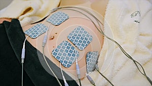 Antiage procedure. Woman patient getting electro stimulation of tummy. Rejuvenate procedure. Hardware cosmetology.