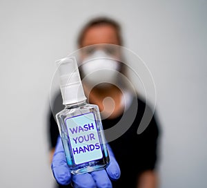 Antibacterial gel in NHS nurse hand - WASH YOUR HANDS photo