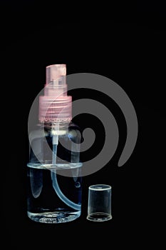 Antibacterial spray against bacteria, covid 19 and bacteria.  One clear plastic bottle with a spray pump isolated on a black