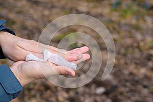 Antibacterial treatment of hands before eating in nature. the man wipes his hands with a damp cloth from viruses and bacteria.