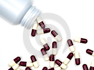 Antibiotic capsules pills spilling out of plastic bottle isolated on white background with copy space.