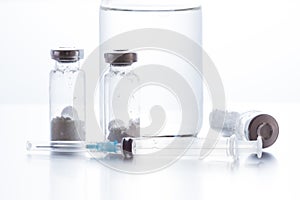 Antibiotic injection bottles with a plastic disposable syringe on a white background