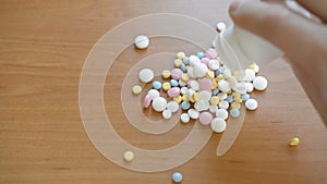 Antibiotic pills falling from a bottle on a table top view