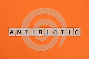 Antibiotic word made from wooden letters on orange background