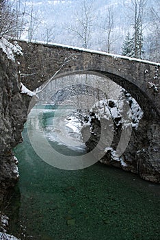 Antic bridge over a green river