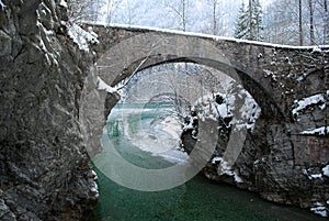 Antic bridge over a green river