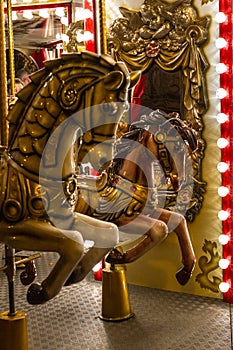 Antic retro carousel with golden horses mirrors and lamps