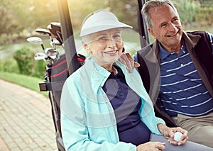 Anticipating a great game today. Portrait of a smiling senior couple riding in a cart on a golf course.