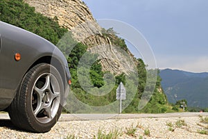 Anticline geological feature with front of Mazda MX5 in foreground.