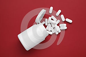 Antidepressants and medical bottle on red background, flat lay