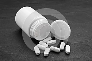 Antidepressants and medical jar on black background