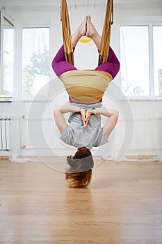 Antigravity yoga, woman in hammock and doing asana