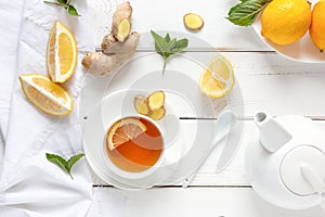 Antioxidant healthy tea with lemon, ginger and mint on a white wooden table. Alternative medicine concept