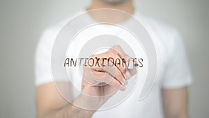 Antioxidants, man writing on transparent screen photo