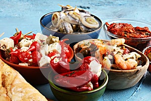 Antipasti Appetizer sweet cherry peppers stuffed with soft cheese feta, olives with oil. Seafood and anchovies with olives and