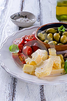 Antipasti plate of parmesan, cherry tomatoes, olives and almonds