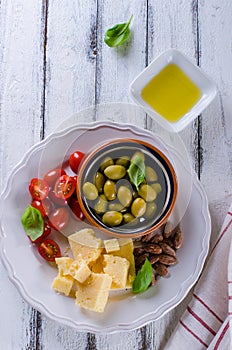 Antipasti plate of parmesan, cherry tomatoes, olives and almonds