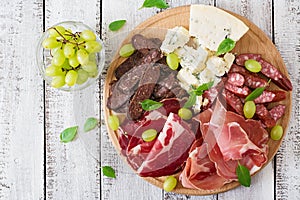 Antipasto catering platter with bacon, jerky, sausage, blue cheese and grapes