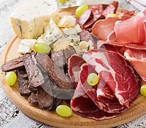 Antipasto catering platter with bacon, jerky, sausage, blue cheese and grapes