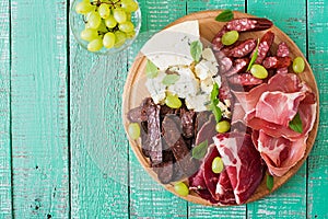 Antipasto catering platter with bacon, jerky, sausage, blue cheese and grapes