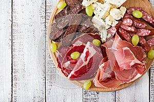 Antipasto catering platter with bacon, jerky, sausage, blue cheese and grapes