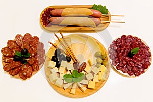 Antipasto platter assorted sliced cheeses, sausages, salami with olives and crackers on wooden plates. Appetizer, catering food