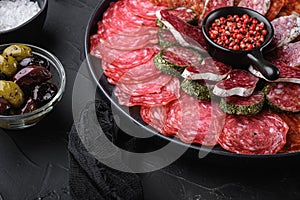 Antipasto platter cold meat with chorizo, fuet,salami, salchichon and longaniza on black textured background photo