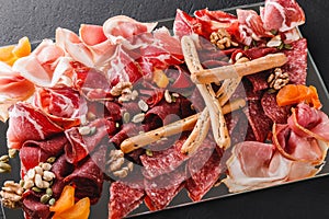 Antipasto platter cold meat with grissini bread sticks, prosciutto