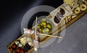 Antipasto Platter Cold meat plate with grissini bread sticks, olives, tomatoes, quail eggs on wooden board