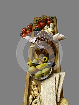 Antipasto Platter Cold meat plate with grissini bread sticks, olives, tomatoes, quail eggs on wooden board