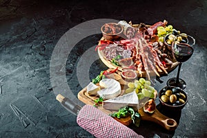 Antipasto platter with ham, prosciutto, salami, blue cheese, mozzarella, olives, grissini bread sticks with pesto