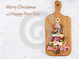 Antipasto platter with ham, prosciutto, salami, cheese,  crackers and olives on a wooden background.