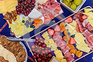 Antipasto platters with prosciutto, cheese, strawberries, grapes, dried fig