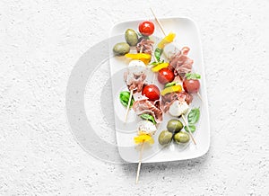 Antipasto skewers. Mediterranean appetizer to wine - prosciutto, bell peppers, cherry tomatoes, mozzarella cheese on skewers. Deli