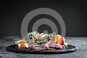 Antipasto with traditional Spanish meat snacks on a slate board, Antipasto platter. catering, banner, menu, recipe
